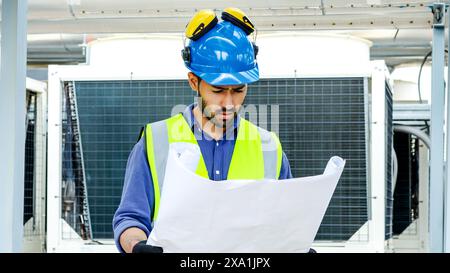 Ein Bauarbeiter in einem Industriegebiet, der Dokumente hat. Stockfoto