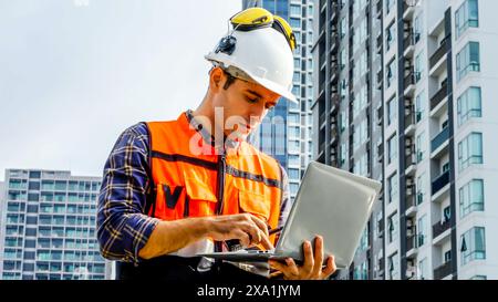 Ein Ingenieur, der auf einer Baustelle einen Laptop benutzt. Stockfoto