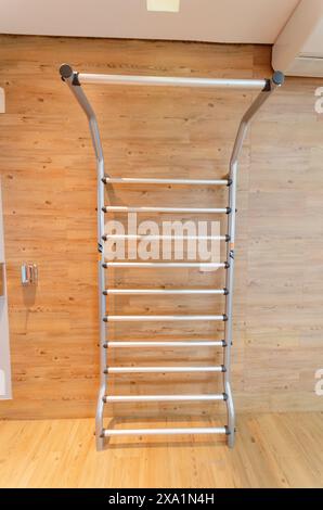 Leiter hängt an Holzwand mit Holzboden Stockfoto