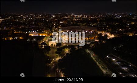 Römisches Kolosseum in Rom, Italien mit Blick auf den Konstantinsbogen. Wunderschöne Luftaufnahme des berühmten Flavianischen Amphitheaters bei Nacht Stockfoto
