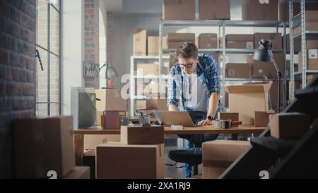 Inventory Manager verpackt einen stilvollen Fahrradsitz, der online an einen Kunden verkauft wird. Ein kleines Papppaket für das Porto vorbereiten. Junger Inhaber kleiner Unternehmen, der im Lager arbeitet. Stockfoto