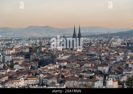 Ein Blick aus der Vogelperspektive auf die Stadt Clermont-Ferrand bei Sonnenuntergang vom Parc de Monjuzet. Stockfoto