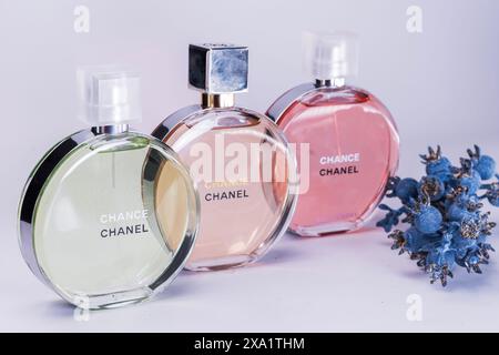 Drei Parfümflaschen mit verschiedenen Blumen im Hintergrund Stockfoto