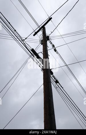 Die Linien der Telefonmasten sind vor einem bewölkten Himmel geschildert Stockfoto