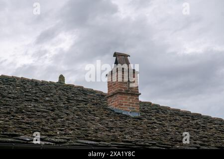 Gemauerter Kamin auf Steindach, ländliches Gebäude in der Vorgebirgsgegend, altes Gebäude. Stockfoto