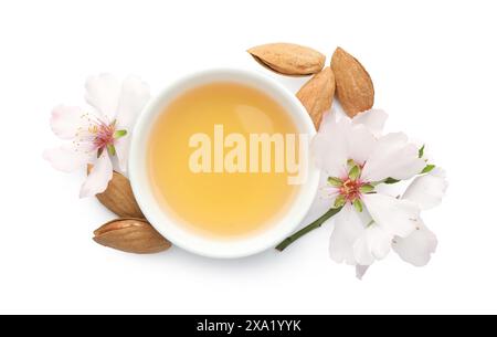 Mandelöl in der Schüssel, frische Nüsse und wunderschöne Blumen isoliert auf weiß, Blick von oben Stockfoto