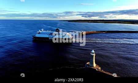 Zwei große Boote in der Nähe von Pier und Leuchtturm im Wasser Stockfoto