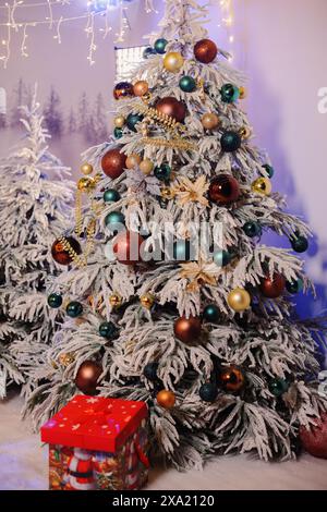 Ein festlicher Weihnachtsbaum, umgeben von Geschenken, Schnee und funkelnden Lichtern Stockfoto