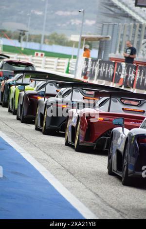 Bunte Autos, die tagsüber in einer Schlange auf einer Rennstrecke fahren Stockfoto