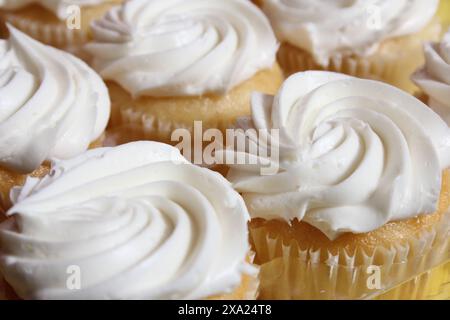 Die köstlichen Cupcakes mit cremiger weißer Glasur wirbeln Stockfoto