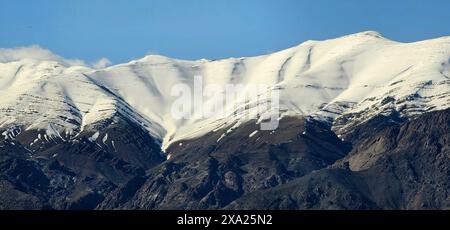 Ein schneebedeckter Berg mit zwei Personen an der Seite Stockfoto