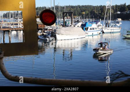 Kleine weiße Boote im Yachthafen mit Leuten an Bord Stockfoto