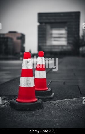 Eine selektive Farbe von Verkehrskegeln auf dem Boden auf dem unscharfen Hintergrund Stockfoto