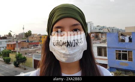 Mädchen mit Maske, um sich vor dem Coronavirus zu schützen. Covid-19-Pandemie. Coronavirus in Maske geschrieben Stockfoto