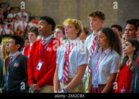 Multirassische Schüler an einem Schulstand in Südkalifornien, während sie eine Predigt bei einer Schulmesse hören. Stockfoto