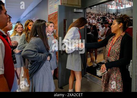 Ein Lehrer an einer katholischen High School in Südkalifornien inspiziert multirassische Schüleruniformen auf ordentliche Kleidung, wenn sie das Gymnasium für A betreten Stockfoto