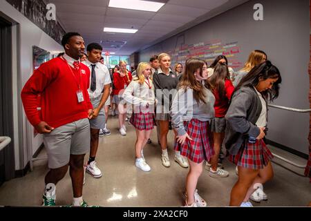 Multirassische Schüler einer katholischen High School in Südkalifornien überprüfen ihre Uniformkleidung auf ordentliche Kleidung, wenn sie das Gymnasium für eine Schule betreten Stockfoto