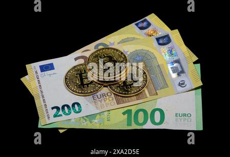 Eine Nahaufnahme von Euro-Banknoten und Bitcoin-BTC-Münzen. Stockfoto