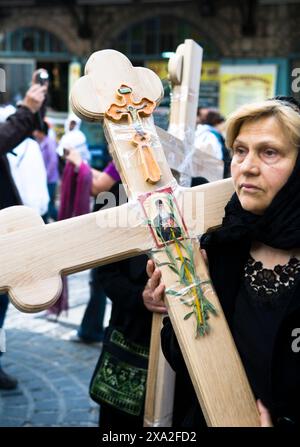 Ein serbischer Pilger, das Kreuz tragend, während die Karfreitagsprozession in der Via Dolorosa in der Altstadt von Jerusalem. Stockfoto