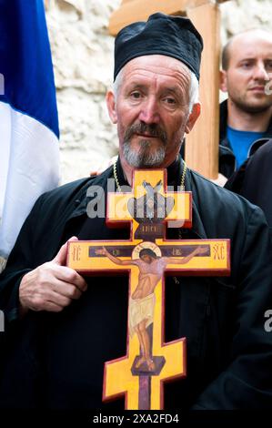 Ein serbischer Pilger, das Kreuz tragend, während die Karfreitagsprozession in der Via Dolorosa in der Altstadt von Jerusalem. Stockfoto