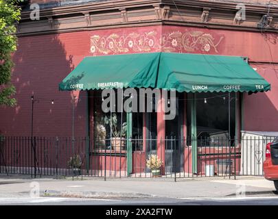 Kleines Café mit Markise Schild mit Frühstück Mittagessen Kaffee Tee in einem roten Backsteingebäude Jersey City, NJ Stockfoto