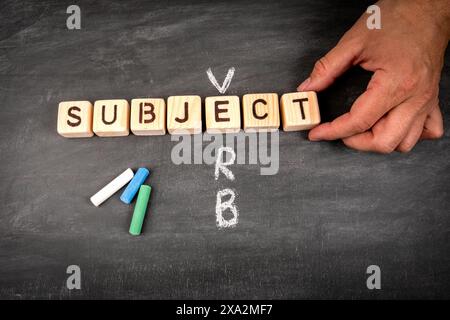 Subject-Verb. Kreuzworträtsel aus Holzblock und Kreideflächen auf einem Tafel-Hintergrund. Stockfoto