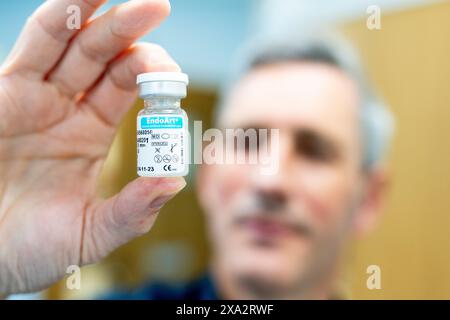 Thomas Poole, Augenarzt des Frimley Health NHS Foundation Trust, hält ein Fläschchen mit einer künstlichen Hornhaut, während Frimley Health die erste kommerzielle Transplantation des Landes mit einer künstlichen Hornhaut im Frimley Park Hospital in Surrey durchführt. Bilddatum: Dienstag, 28. Mai 2024. Stockfoto