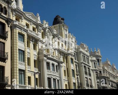 Reihe historischer Gebäude mit detaillierten Fassaden und blauem Himmel im Hintergrund an einem sonnigen Tag, madrid Stadt in spanien mit hohen Gebäuden, Denkmälern Stockfoto