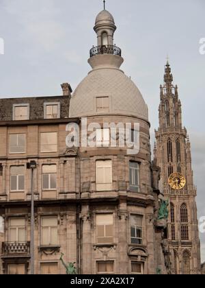 Historisches Gebäude mit gemischter Architektur aus Kuppel und Turm mit Uhr vor bewölktem Himmel, historische Gebäude am Marktplatz in Antwerpen Stockfoto