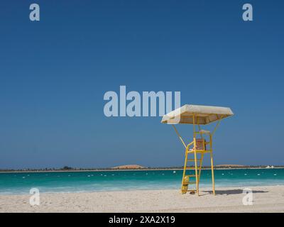 Verlassener Rettungsschwimmer-Turm an einem einsamen Strand mit blauem Himmel und ruhigem Meer, Abu Dhabi, Arabische Emirate Stockfoto