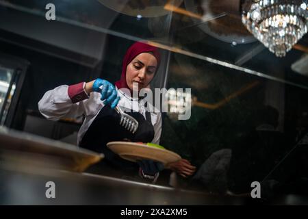 31. Mai 2024, Afyonkarahisar, Türkei: Eine Frau bereitet das Essen der weltberühmten Stadt zum Servieren zu. Afyonkarahisar, eine Stadt in der Türkei, zieht mit ihren archäologischen Ruinen, die die Kultur und Kunst des Phrygischen Königreichs und anderer tausendjähriger Zivilisationen widerspiegeln, der berühmten Phrygischen Straße, den über Millionen Jahre entstandenen Höhlen und den ersten Wohngebäuden in der Geschichte der Menschheit Aufmerksamkeit auf sich. Thermaltourismus mit der einzigen Mitgliedschaft des Europäischen Historic Thermal Towns Association (EHTTA) im Land und dem von der UNESCO eingetragenen Titel Gastronomy City. (Kreditbild: © Tunahan Turhan/SOPA Stockfoto