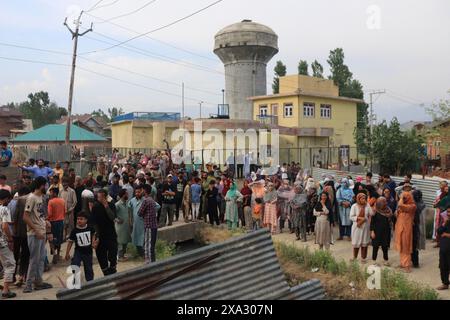 Eine große Menschenmenge versammelt sich in einem städtischen Gebiet in der Nähe eines Wasserturms und verschiedener Gebäude, die an einer Veranstaltung oder Beobachtung, Begegnung, Pulwama, Jammu und beteiligt sind Stockfoto