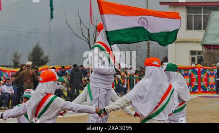 Kinder in weißen Uniformen, die die indische Flagge halten, während sie an einer Parade voller Nationalstolz teilnehmen, Srinagar, Jammu und Kaschmir, Indien Stockfoto