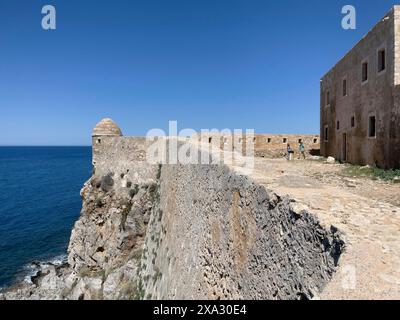 Linker runder Wachtturm und Festungsmauer an der Mittelmeerküste, rechter Teil des Hauses der Ratsherren an der Ecke der Festung Gipfel der Festung Agia Ioustini von Stockfoto