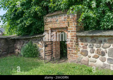 Mauer aus Feldsteinen und Eingang zum Friedhof in Ballerstedt, Sachsen-Anhalt Stockfoto