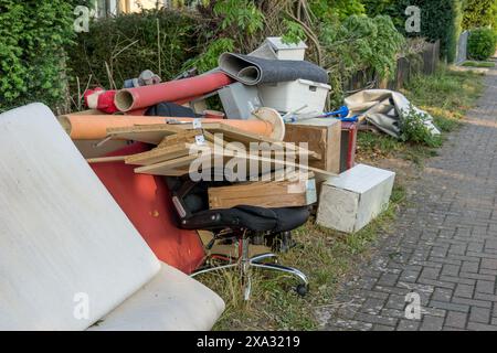 Stapel von Sperrmüll am Straßenrand mit Holzmöbeln, Schubladen und Wäschekorb Stockfoto