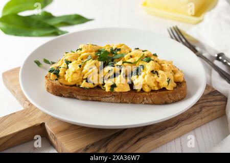 Geröstetes Brot mit Rührei und wildem Knoblauch Stockfoto