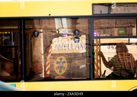 Nicht exklusiv: KIEW, UKRAINE - 3. JUNI 2024 - ein Krankenwagen wird in einem Busfenster in Kiew, Hauptstadt der Ukraine, reflektiert. Stockfoto