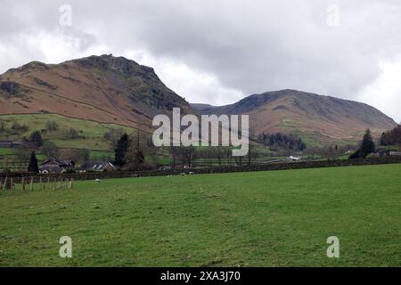 Die Wainwrights „Helm Crag“ und „Steel Fell“ von der A591 beim Swan Hotel in der Nähe von Grasmere im Lake District National Park, Cumbria, England, Großbritannien. Stockfoto