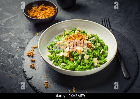 Deutsche Eiernudeln - Spinatspätzle mit Parmesan und gerösteten Zwiebeln Stockfoto