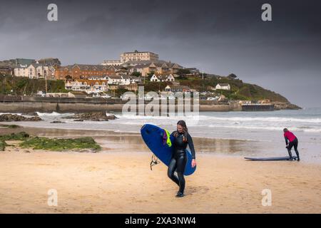 Eine Surferin, die ihr Surfbrett trug, nachdem sie am Towan Beach in Newquay in Cornwall in Großbritannien gesurft hatte. Stockfoto