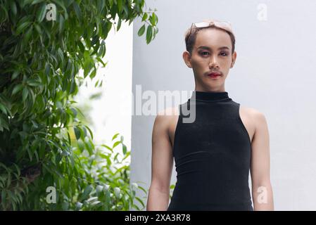 Porträt des schönen asiatischen queeren LGBT Community Unterstützers Mann mit Schnurrbart, der Lippenstift und Jumpsuit trägt Stockfoto