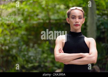 Porträt des schönen asiatischen queeren LGBT Community Unterstützers Mann mit Schnurrbart, der Lippenstift und Jumpsuit trägt Stockfoto