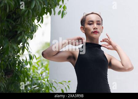 Porträt des schönen asiatischen queeren LGBT Community Unterstützers Mann mit Schnurrbart, der Lippenstift und Jumpsuit trägt Stockfoto