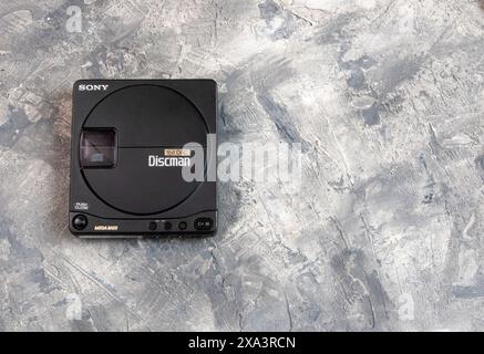 Vintage-CD-Player der Sony Discman, der zu dieser Zeit stilvoll und begehrenswert war, mit verschiedenen Power-Optionen und einem bizarren Paar Kopfhörer Stockfoto