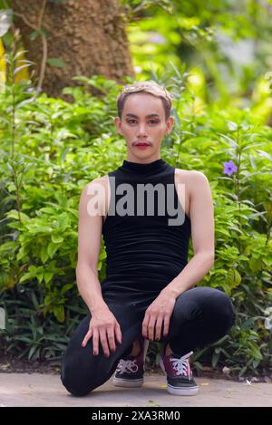 Porträt des schönen asiatischen queeren LGBT Community Unterstützers Mann mit Schnurrbart, der Lippenstift und Jumpsuit trägt Stockfoto