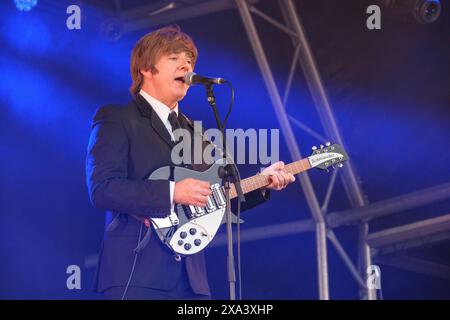 Paul Canning (John Lennon) von den Bootleg Beatles tritt beim Wychwood Festival in Cheltenham auf. Juni 2024 Stockfoto