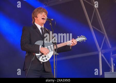 Paul Canning (John Lennon) von den Bootleg Beatles tritt beim Wychwood Festival in Cheltenham auf. Juni 2024 Stockfoto