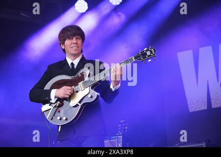 Stephen Hill (George Harrison) von den Bootleg Beatles tritt beim Wychwood Festival in Cheltenham auf. Juni 2024 Stockfoto