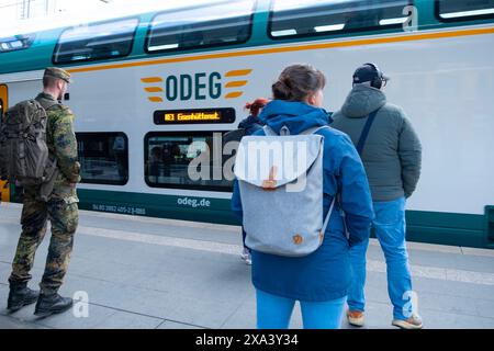 Regionalzug kommt am Berliner Bahnhof an, Passagiere, Militär im Urlaub warten auf Bahnsteig, Verspätung der öffentlichen Verkehrsmittel, tägliche Pendelfahrt, Berlin - April Stockfoto